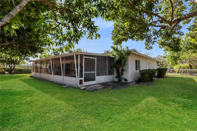 back of house with a sunroom and a yard