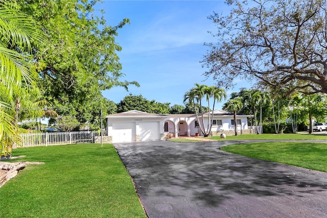 ranch-style house featuring a garage and a front lawn