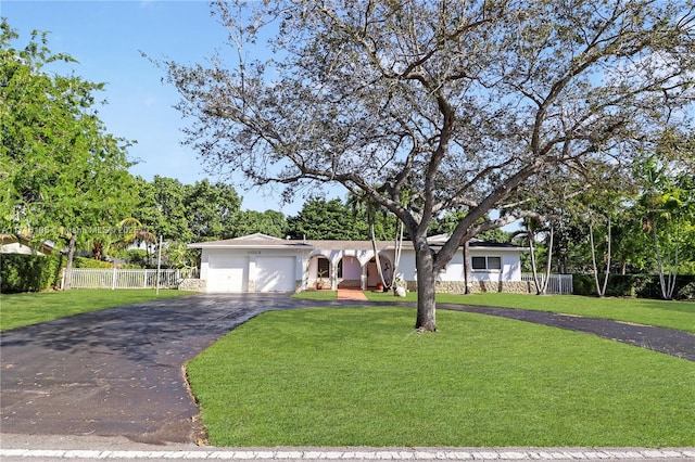 ranch-style house featuring a garage and a front yard