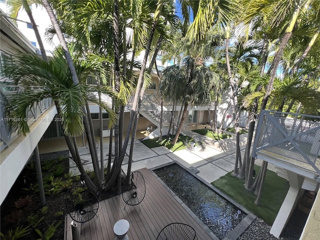 view of property's community with stairs and a patio