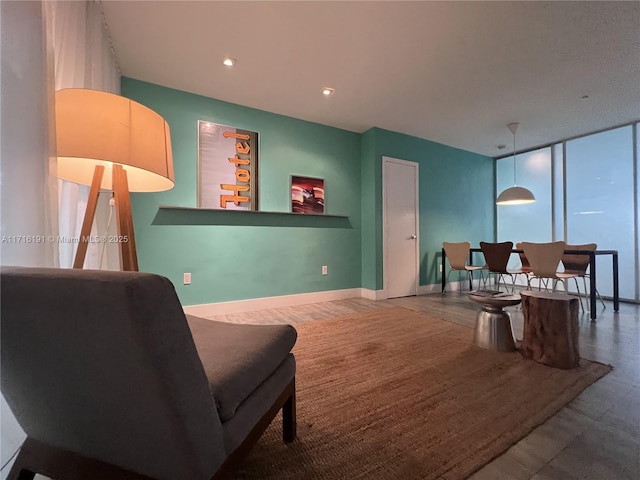 living area featuring recessed lighting, floor to ceiling windows, and baseboards