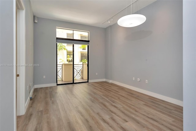 unfurnished room with light hardwood / wood-style floors and track lighting