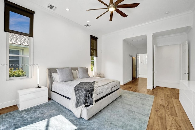 bedroom with ceiling fan, light wood-type flooring, and ornamental molding