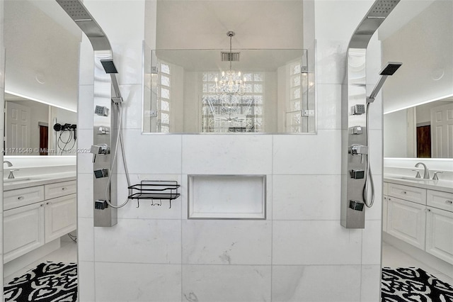 bathroom with tile patterned flooring, a notable chandelier, a tile shower, and vanity