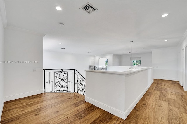 hallway featuring light wood-type flooring and ornamental molding