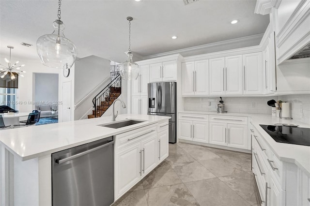 kitchen featuring a kitchen island with sink, hanging light fixtures, sink, white cabinetry, and stainless steel appliances