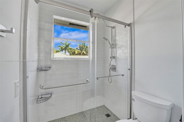 bathroom featuring toilet and an enclosed shower