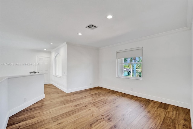 unfurnished room featuring light wood-type flooring and crown molding