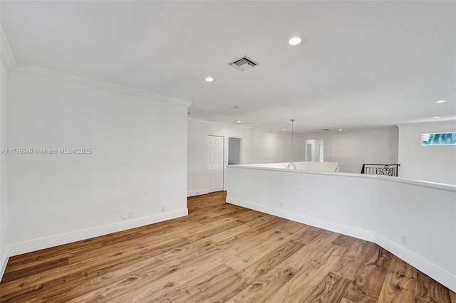 unfurnished room featuring ornamental molding and light wood-type flooring