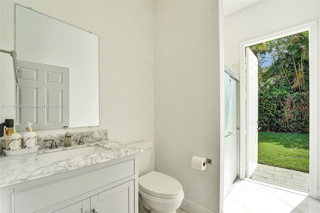 bathroom featuring vanity, an enclosed shower, and toilet