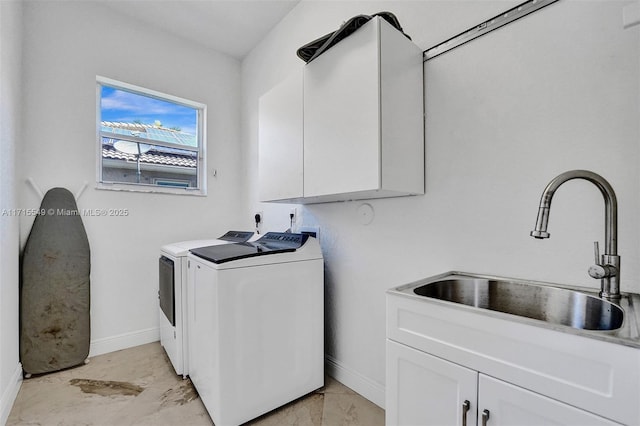 laundry room featuring washer and clothes dryer, cabinets, and sink