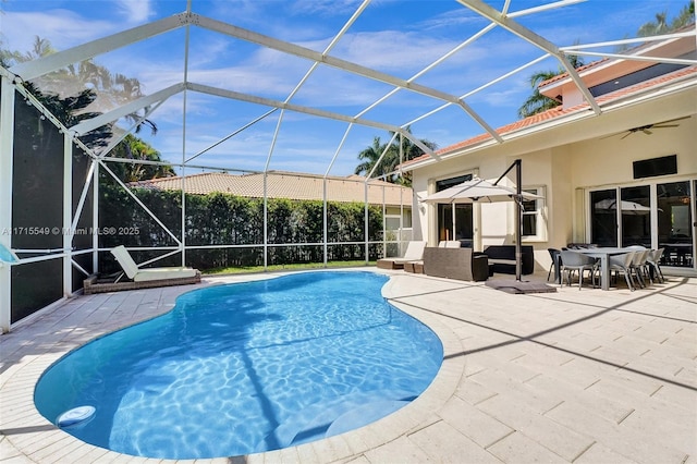 view of swimming pool featuring glass enclosure and a patio