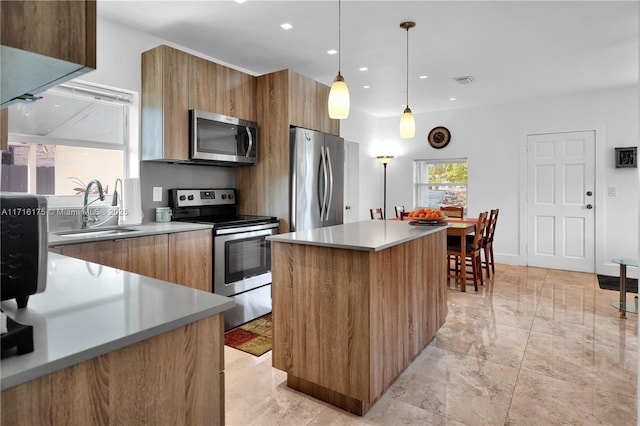 kitchen featuring sink, a center island, hanging light fixtures, and appliances with stainless steel finishes