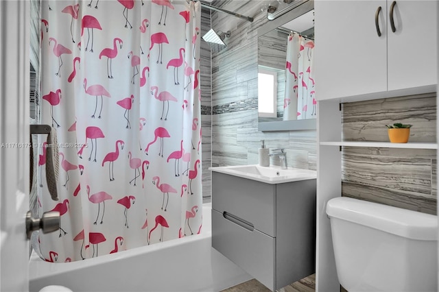 full bathroom with shower / bath combo, tasteful backsplash, vanity, tile walls, and toilet