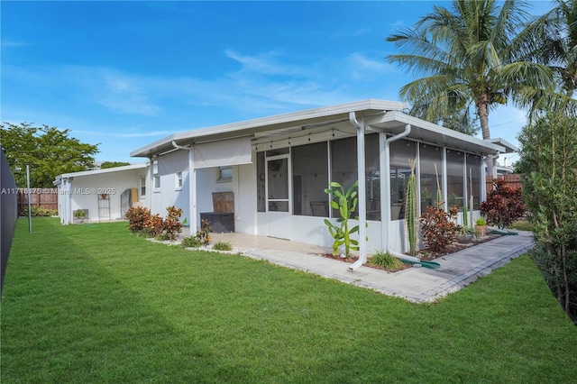 rear view of property with a yard, a carport, and a sunroom