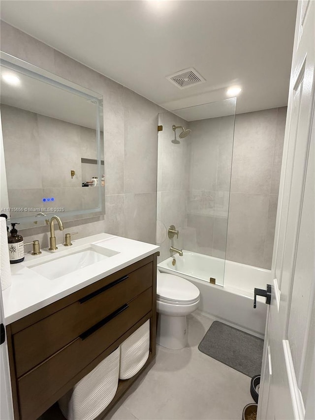 full bathroom featuring toilet, vanity, tile walls, and bathtub / shower combination