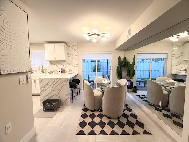 interior space featuring light tile patterned floors, sink, and an inviting chandelier