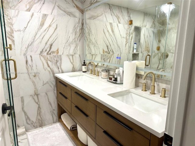 bathroom featuring a shower with door, vanity, and tile walls