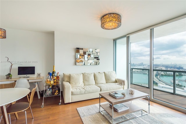 living room featuring hardwood / wood-style flooring, expansive windows, and a water view