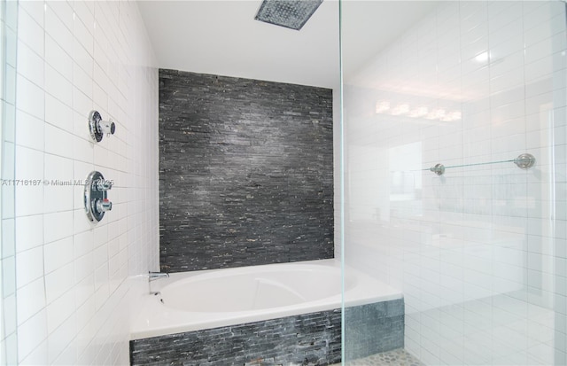 bathroom featuring plus walk in shower and tile walls