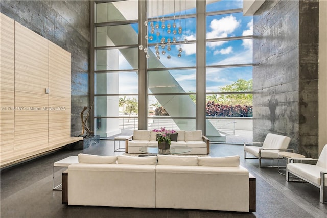 living room featuring a towering ceiling and a wall of windows