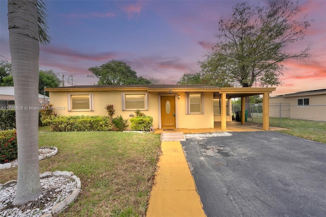 ranch-style home featuring a yard and a carport