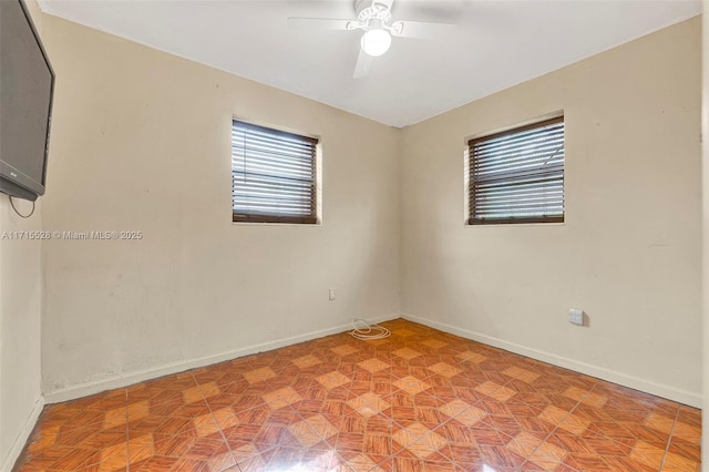 spare room with ceiling fan and light parquet flooring