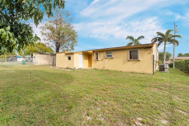 back of property featuring a yard and central AC unit