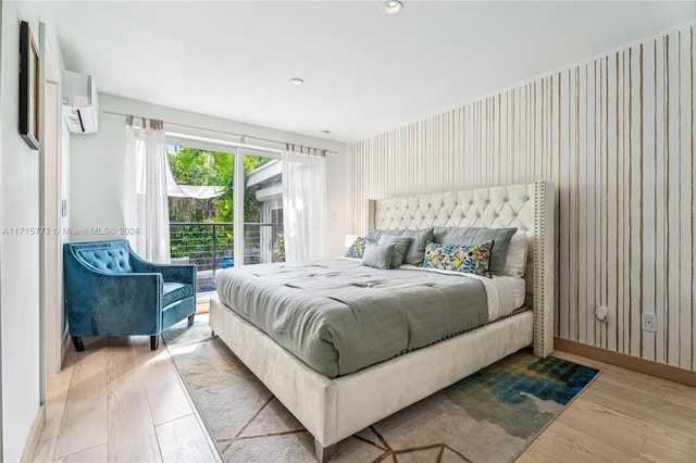 bedroom with light wood-type flooring and a wall mounted AC