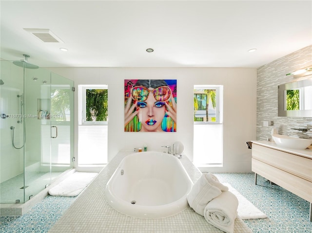 bathroom featuring vanity and independent shower and bath