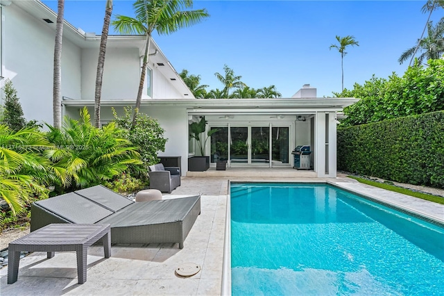 view of pool featuring a patio area and a grill