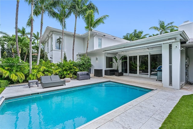 rear view of property featuring a patio and outdoor lounge area