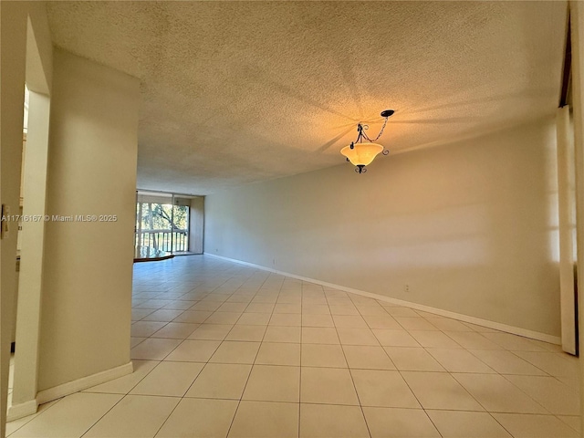 unfurnished room featuring light tile patterned floors and a textured ceiling