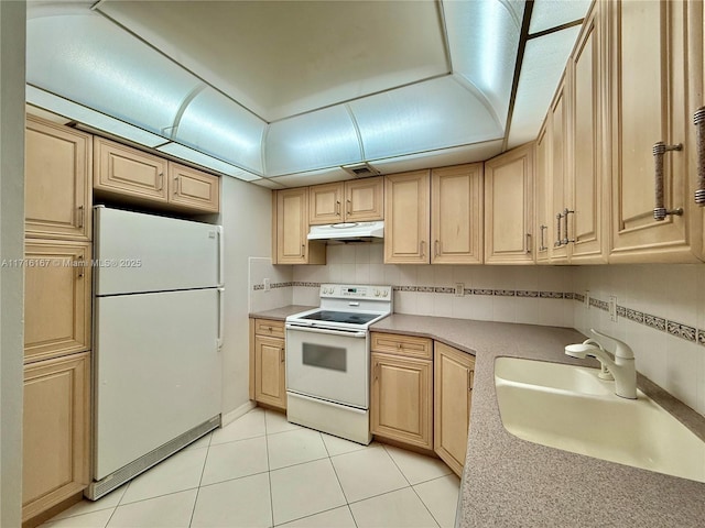 kitchen with light brown cabinets, white appliances, and sink