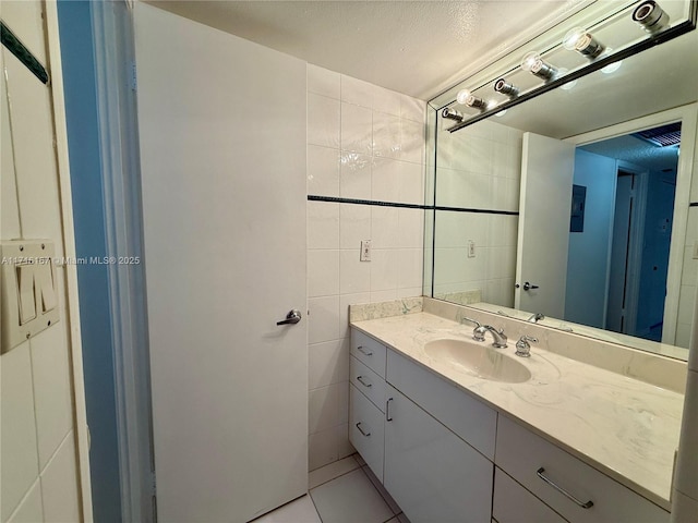 bathroom featuring tile patterned floors, vanity, and tile walls