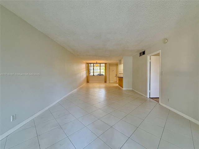 tiled empty room with a textured ceiling