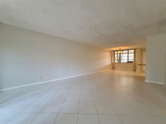 empty room with light tile patterned floors and a textured ceiling