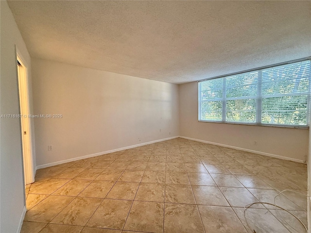 tiled empty room with a textured ceiling