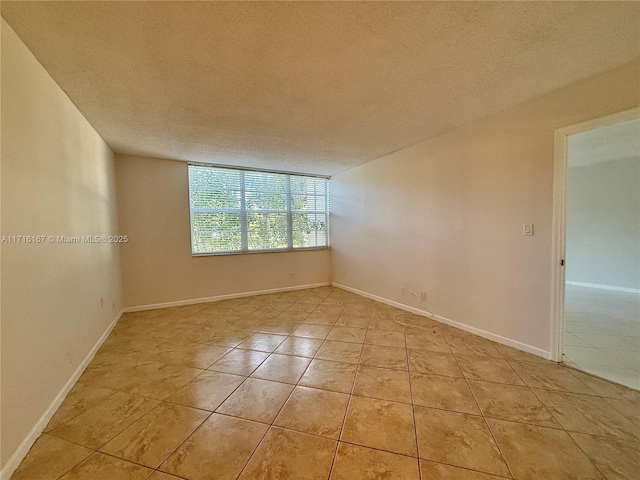 empty room featuring light tile patterned flooring and a textured ceiling