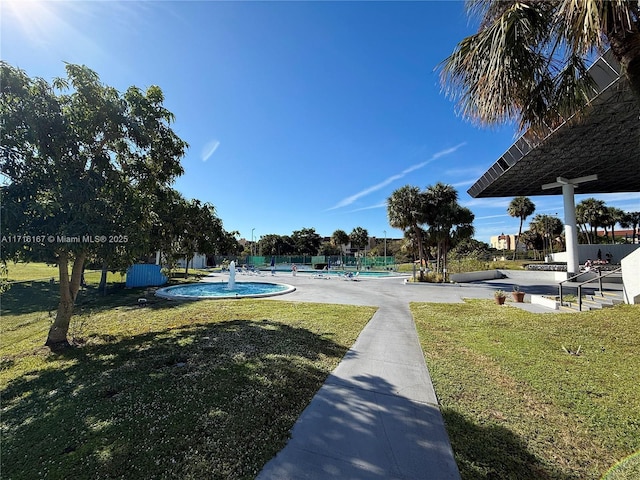 surrounding community with a yard and a pool