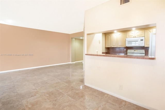 kitchen featuring vaulted ceiling, range, and tasteful backsplash