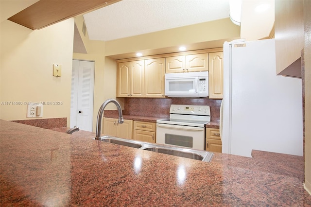 kitchen with backsplash, kitchen peninsula, sink, and white appliances