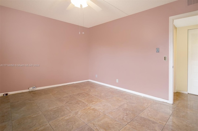 spare room featuring ceiling fan and light tile patterned floors