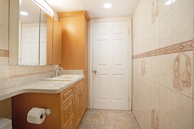 bathroom with vanity and tile walls