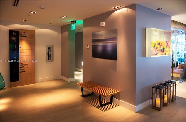 hallway featuring electric panel and light hardwood / wood-style floors