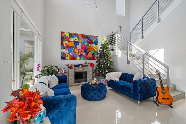 living room with light tile patterned floors, a fireplace, and a towering ceiling