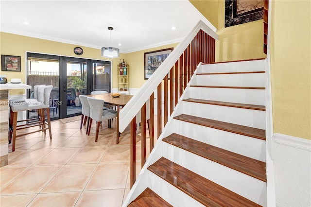 tiled dining space featuring crown molding and french doors