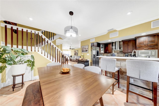 dining space featuring ceiling fan, ornamental molding, and light tile patterned floors