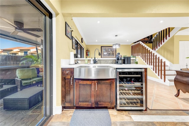 bar with ceiling fan, sink, beverage cooler, crown molding, and pendant lighting