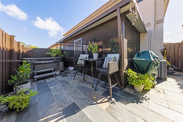 view of patio featuring a hot tub and a grill